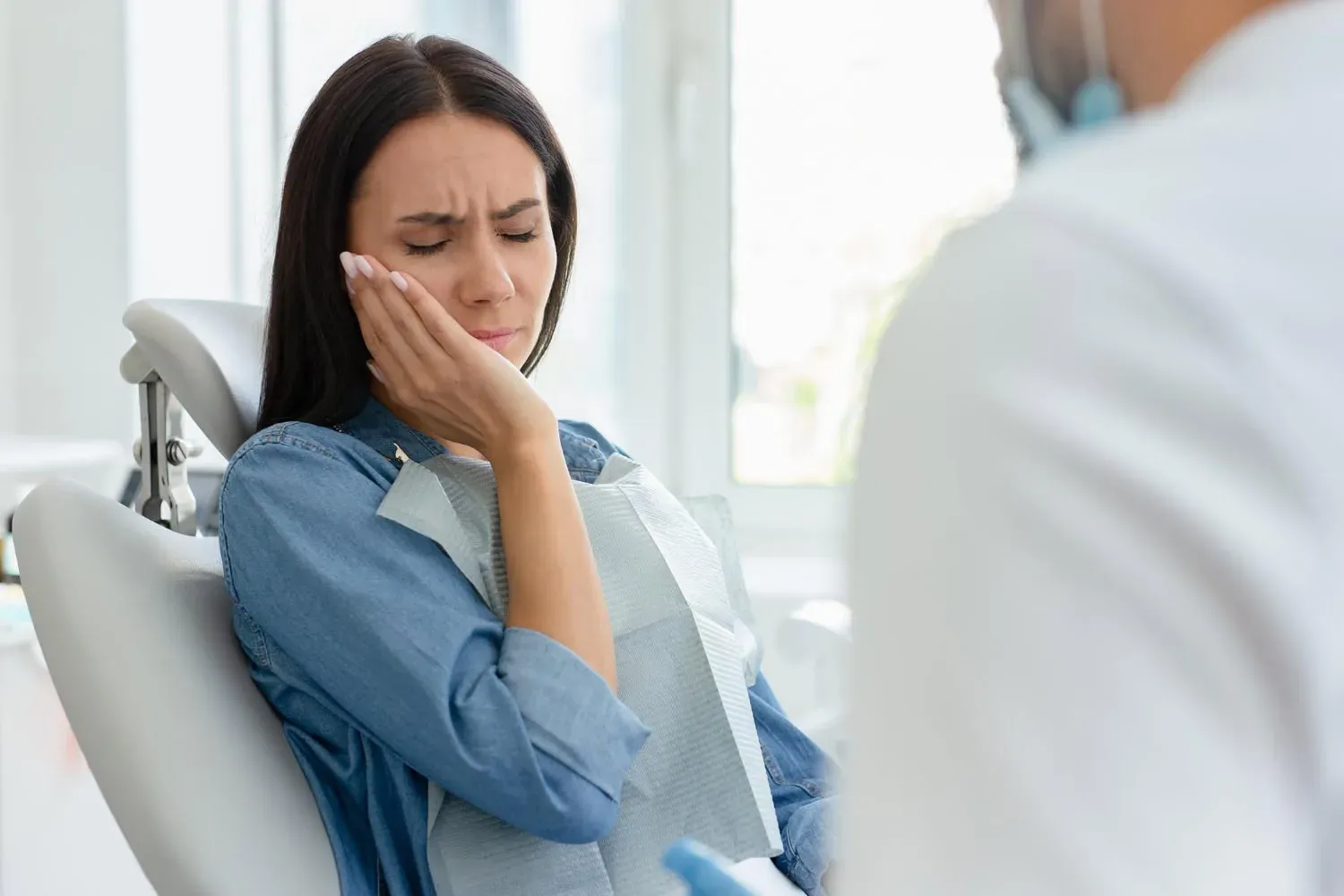 Dental patient experiencing discomfort at Neola Dental in Minneola, FL.