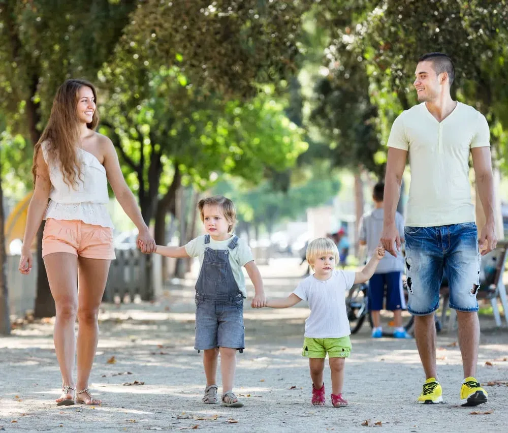 Family enjoying a walk outdoors in Minneola, Florida, with bright smiles and happy faces.