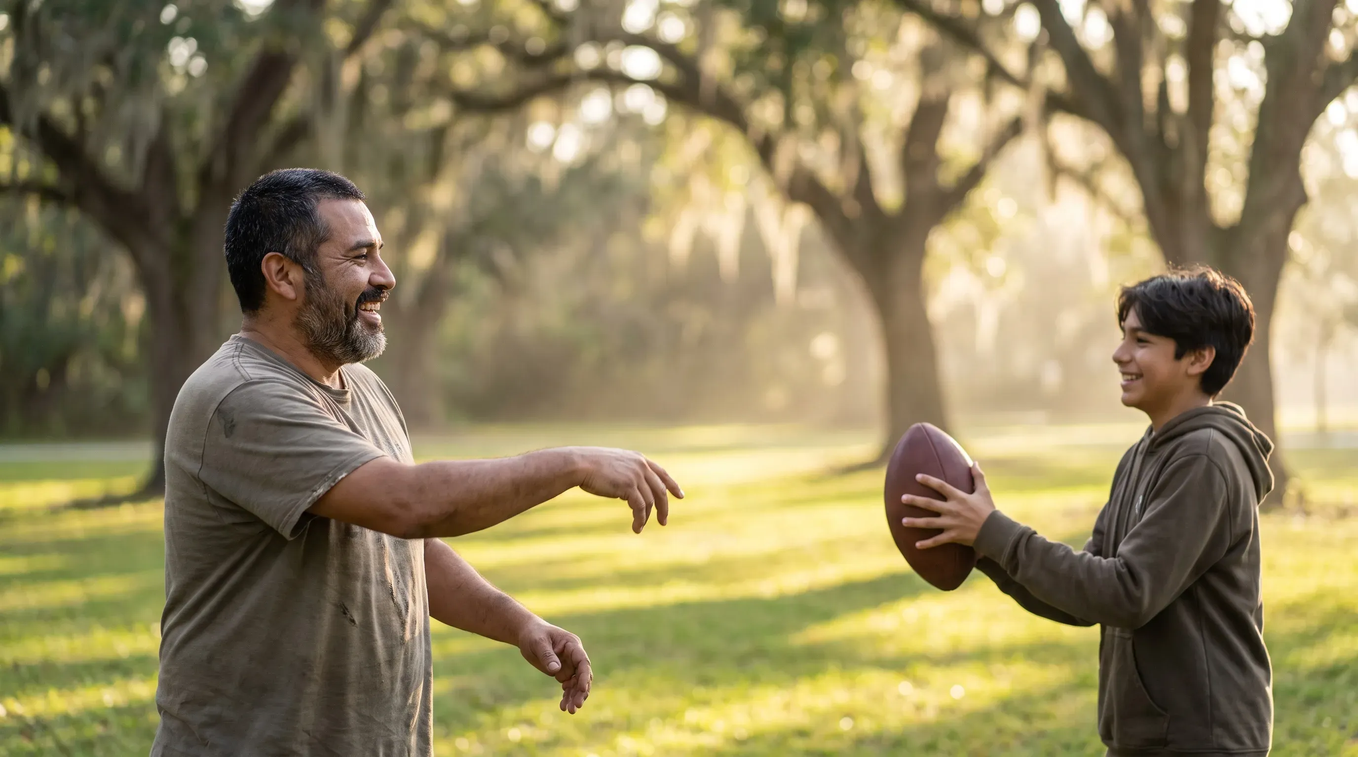 Padre e hijo adolescente sonriendo mientras juegan con un balón en un parque cerca de Minneola, FL.