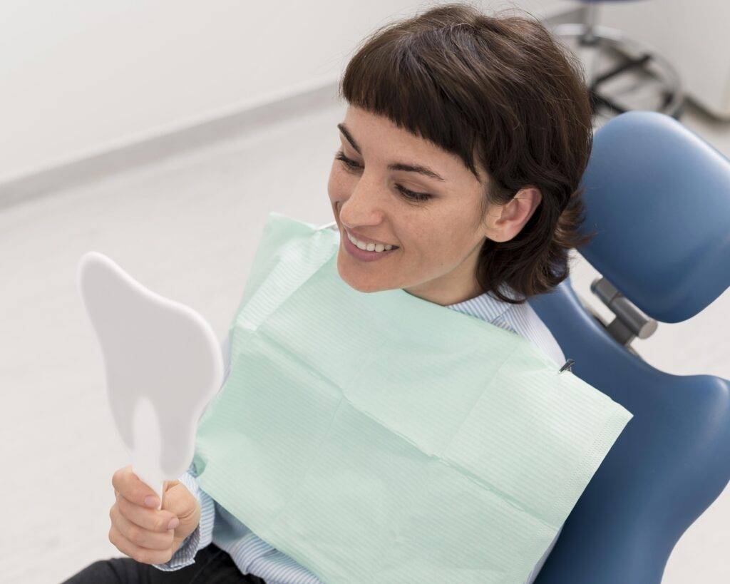 female patient looking mirror after dental procedure